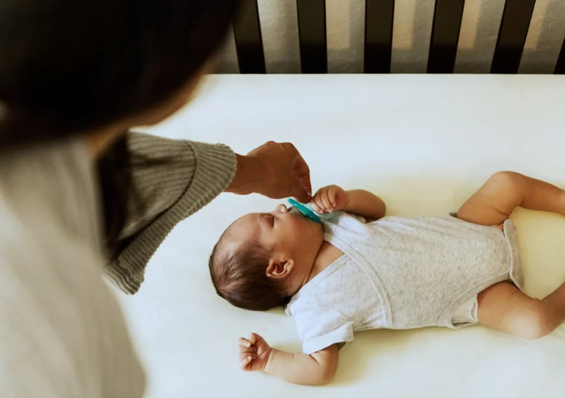 baby-sleeping-in-crib-mom-offering-pacifier1-scaled09